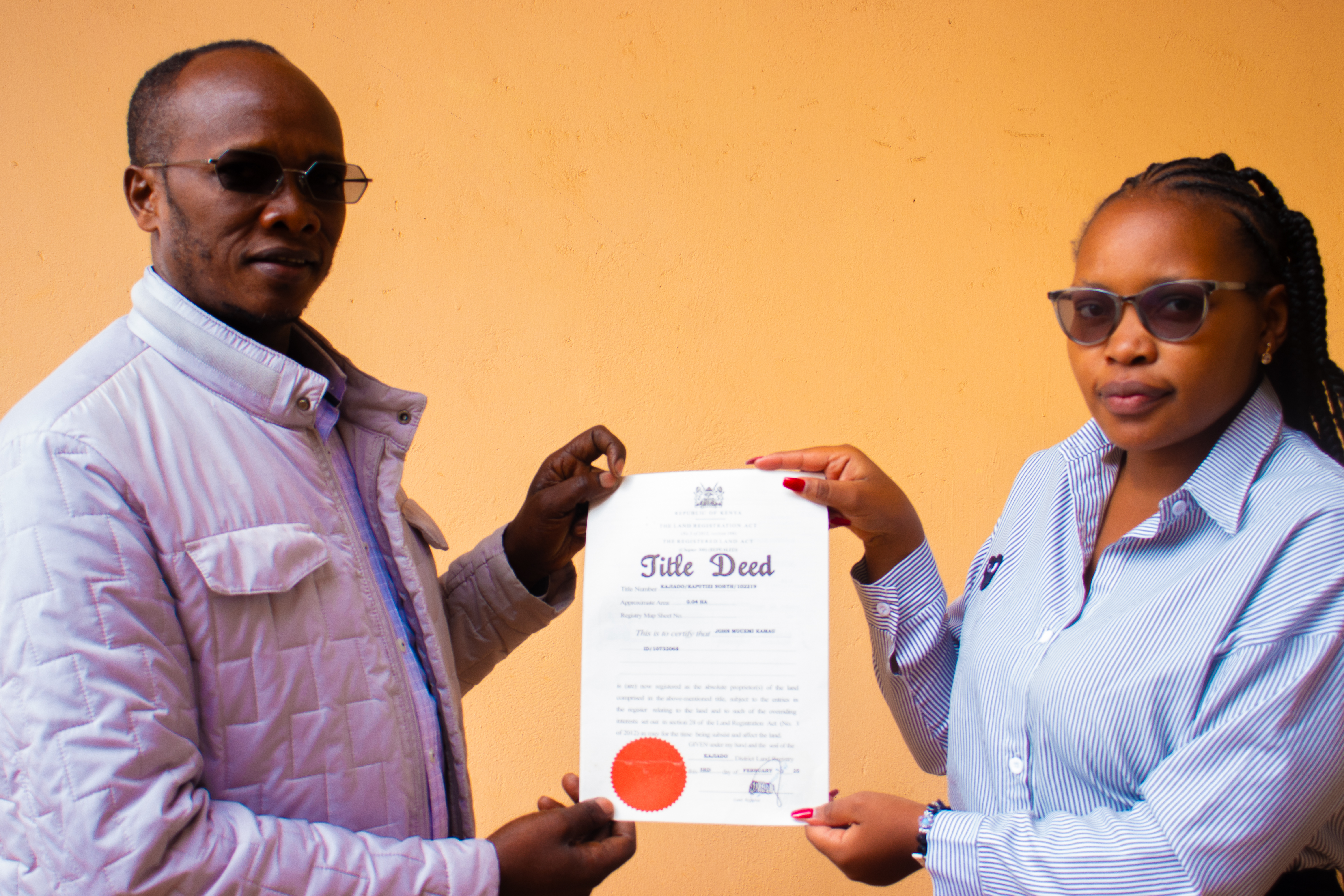 Legal Officer, Ms. Anastasia Kemunto handing over to client